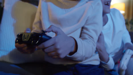 Close-Up-On-Hands-Of-Two-Young-Boys-At-Home-Playing-With-Computer-Games-Console-On-TV-Holding-Controllers-Late-At-Night-10
